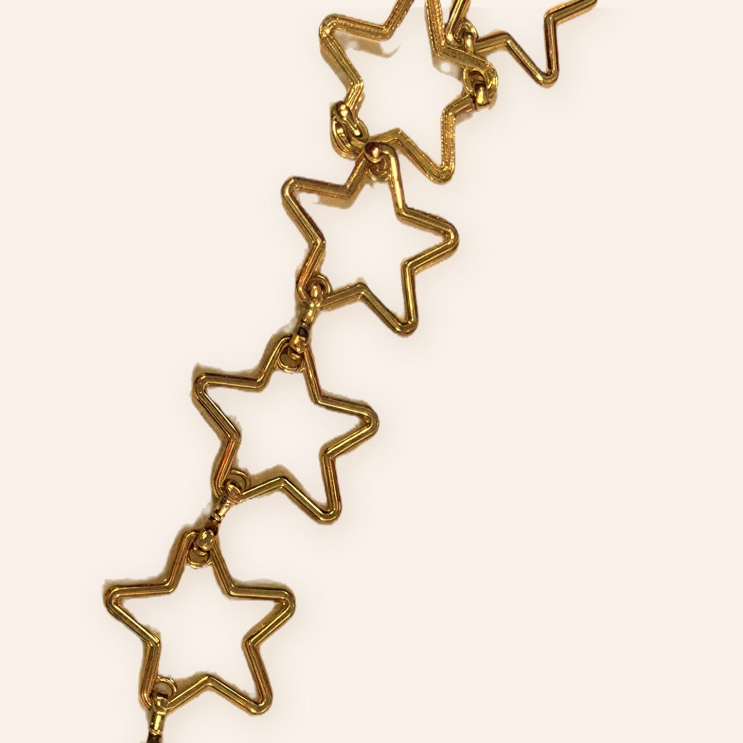 Detalle de los eslabones en forma de estrella calada del cinturón dorado