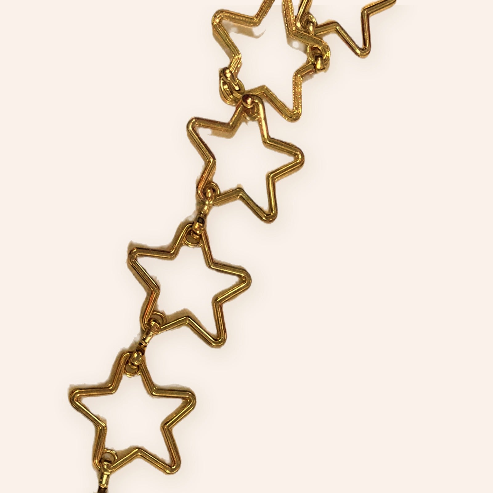 Detalle de los eslabones en forma de estrella calada del cinturón dorado